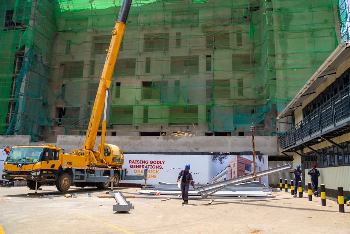Crane at the netted structure with Raising Godly Generations banner